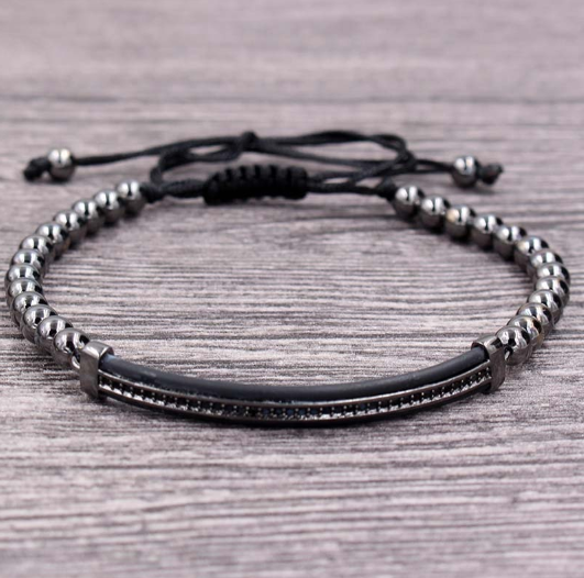 Close-up of the gold beaded bracelet showing shimmering beads and black band